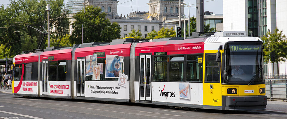 Blick auf eine Tram in Berlin Mitte, mit Werbung von Vivantes, Netzwerk für Gesundheit